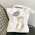 Kawaii white canvas tote bag with a hand-drawn orange cat carrying a grey umbrella print - Ginger Cat with Grey Umbrella