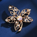 Macro shot of gold clover brooch with sparkling crystals on a deep blue backdrop - Five-leaf Clover Style