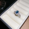 Macro-opname van een blauwe ovale zirkoonring met pavé-stenen op een zilveren band - Blauwe Ovalen Stijl / Blauw