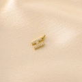 Macro shot of gold-plated H letter pendant with cubic zirconia on champagne silk - Letter H / Gold