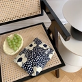 Close-up of cotton floral makeup bag with Nordic pattern on a rustic rattan chair - Large Black Flower