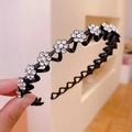 Elegante cerchietto nero con fiori di strass scintillanti mostrato per acconciature - Cerchietto con fiori di prugno in strass bianchi