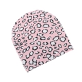 Nahaufnahme der rosa Strickmütze mit Leopardenmuster und schwarz-weißen Flecken auf Weiß - Rosa