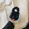 Piccola borsa nera a pieghe con grande manico di perle e catena dorata - Nero