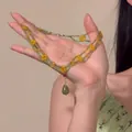 Gros plan d'un collier de perles artisanal à double rang avec fleurs jaunes et perles vertes - Vert-Jaune-Double Couche