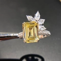 Macro shot of an emerald-cut yellow zircon ring with floral side stones and a diamond band - US 6 / Yellow