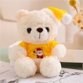 Close-up of beige teddy bear in yellow Christmas hat and shirt with Santa print - Yellow T-shirt Style (White Bear)