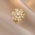 Anello dorato a fiocco di neve con zirconi su uno sfondo di tessuto beige morbido - Anello Fiocco di Neve Micro Intarsiato (J0772)