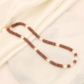 Detail of natural stone necklace with red jasper beads and pearls on marble display - 4# Sesame Red Emperor Stone