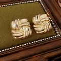 Detalle de pendientes cuadrados trenzados dorados sobre terciopelo verde con brillo pulido - Pin de acero inoxidable - Dorado