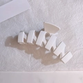 Macro di una grande clip per capelli bianca opaca con design geometrico traforato - Bianco