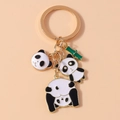 Dettaglio del portachiavi dorato con panda in smalto bianco e nero e ciondoli di bambù - Panda Carino