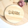 Eleganter Haarclip aus Goldmetall mit dreifachem Herzdesign auf Holzsockel - Goldene Drei Herzen