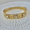 Exquisites vergoldetes Edelstahl-Armband mit funkelnden, kristallbesetzten X-Mustern - Großes X-Design Gold Armreif