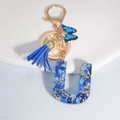 Blue resin letter U keychain with tassel and butterfly charm in gold finish - Letter U