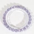 Dettaglio di perle in pietra occhio di gatto lavanda con effetto ottico e filo elastico - Viola