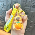 Cute yellow Capybara keychain with rotating face and orange ball detail. - Sitting Electroplated Style - Yellow