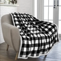 Detail of buffalo plaid flannel blanket with sherpa lining draped on a modern armchair - White Plaid
