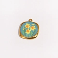 Détail d'un pendentif carré doré avec émail bleu et motif floral de jonquilles jaunes - Style Jonquille Bleue