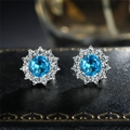 Blue zircon sunflower stud earrings in silver setting on black jewelry box - Aqua