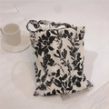 Détail du motif floral noir et blanc sur le sac à main en toile de coton - Fond Noir Branches