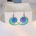 Macro shot of iridescent nautilus shell hollow-out earrings on a jewelry box edge - Iridescent Conch