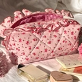 Quilted floral makeup bag in pink with ruffle edges and check lining on white bedding - Pink Rose Ruffle Style
