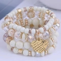 Multi-layer white acrylic crystal beaded bracelet with gold heart pendant detail - Four-Piece Set / Off White