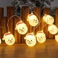 LED Christmas snowman string lights with warm yellow glow on a wooden fence - Snowman Head with Hat