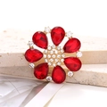 Detailed close-up of a red teardrop crystal flower shoe charm with a golden alloy base - Red