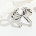 Nahaufnahme eines silbernen Schleifenrings auf Stein mit eleganten Glanzeffekten - Stereo-Schleife / Silber