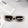 Detail of matte beige rectangular kids sunglasses with grey lenses on a grey background - Gray