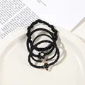 Close-up of black elastic hair ties set with heart and flower charms in a white dish - 4Pcs Set - Pineapple Style / Black