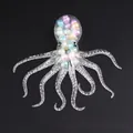 Transparent octopus squishy toy with colorful macaron beads inside on black background - Bulk Packaging / Colored Beads