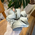 Detail view of large light blue satin hair scrunchie with elegant ruffled texture - Morandi Green
