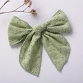 Close-up of light green cotton bow clip with fine floral embroidery and eyelet details - Dark Green