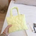 Dettaglio di una mini borsa trapuntata giallo chiaro con ricami floreali e morbidi - Giallo chiaro