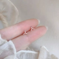 Minimalist 925 sterling silver geometric stud earrings shown on finger for scale - Little Windmill / Silver