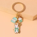Detailed view of a gold metal keychain with rabbit, milk carton, and cupcake charms - Milk Cake Rabbit