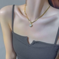 Collana vintage a serpente dorata con pendente a cuore in opale su collo di modella - Collana con Perla a Cuore Dorato (8974)
