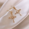 Luxurious gold cross drop earrings with shimmering zircon stones on ivory silk background - Cross Drop Earrings