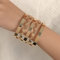 Bracelet manchette géométrique ajouré doré avec rayures métalliques ondulées sur le poignet - Bracelet manchette large à vagues lisses dorées