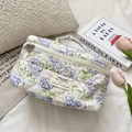 Dettaglio della borsa da trucco trapuntata con fiori blu e morbida trama in puro cotone - Fiore Blu