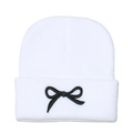 Close-up of white knit beanie featuring intricate black bow embroidery and fine texture - M (56-58cm) / White