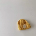 Detailed texture of yellow knitted beanie featuring a white letter N embroidered patch - Yellow