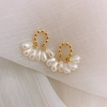 Macro view of French vintage pearl earrings with golden beads on a soft fabric texture - 34 Baroque Tassel Pearl Earrings