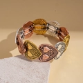 Close-up of vintage tri-color heart-shaped metal link bracelet with radial sunburst texture - Bracelet-Rose Gold