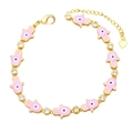Detail of pink enamel Hamsa hand bracelet with evil eye charms and golden finish - Pink