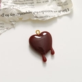 Macro detail of a dark red melting heart pendant with a polished gold hanging loop - Dark Red