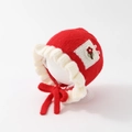 Detail of red knit baby hat featuring cream ruffle trim and small floral embroidery - 50cm 1-2 Years / Pocket Flower-Red